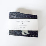 Black and white soap bar with 'Among the Flowers' label on a white background
