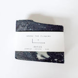 Black and white soap bar with 'Among the Flowers' label on a white background