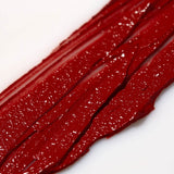 Close-up of red Axiology 'Strength"  lipstick swatch on a white background