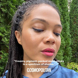 Woman with braided hair wearing pink Attitude lipstick outdoors with text overlay