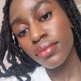 Close-up of a person with braided hair and Axiology lipstick in shade True