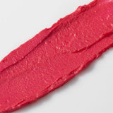 Close-up of a swatch of Axiology Tinted Dew Humble pink lipstick on a white background