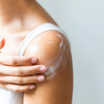 A close-up of a person's shoulder and upper arm with white Little Seed Farm Botanical Butter applied