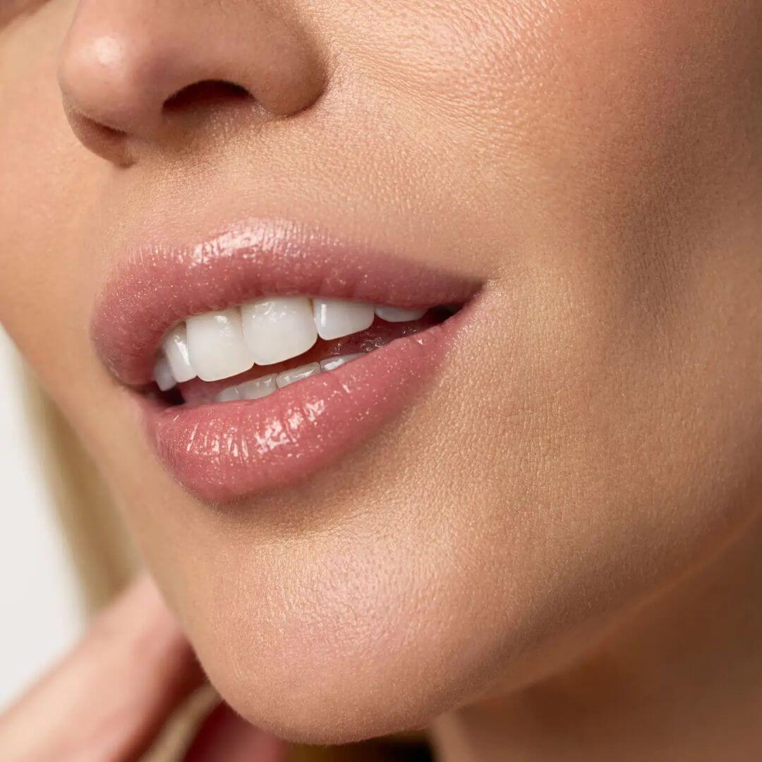 Close-up of a woman's lips wearing Kari Gran Rosie Gold Lip Whip