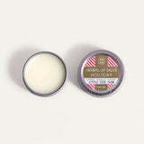 An open round metal tin of Little Seed Farm Holiday lip salve 