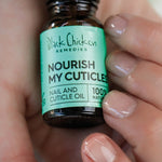 Hand holding a bottle of Black Chicken Remedies Nourish My Cuticles nail and cuticle oil.
