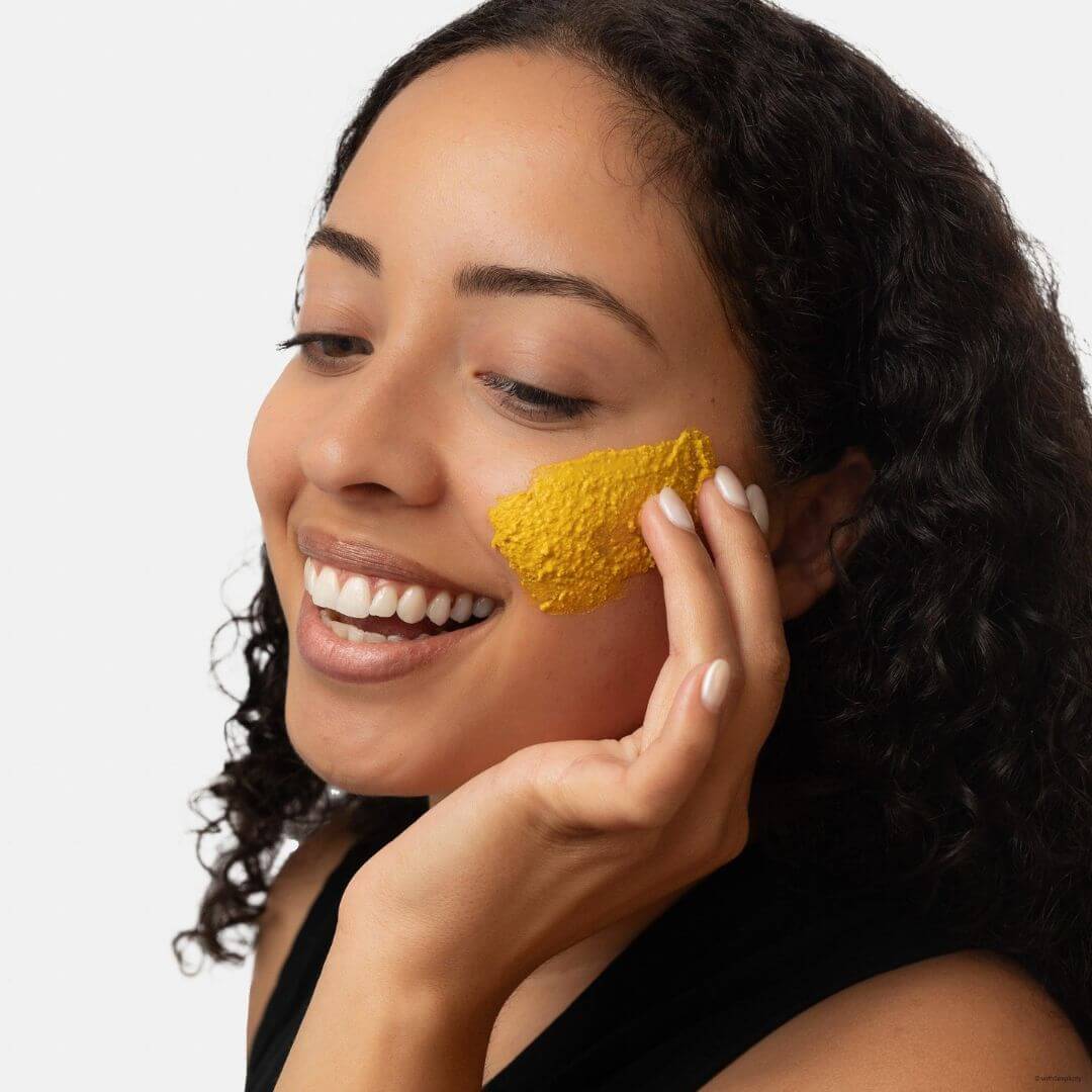Woman applying withSimplicity brightening vitamin c face mask