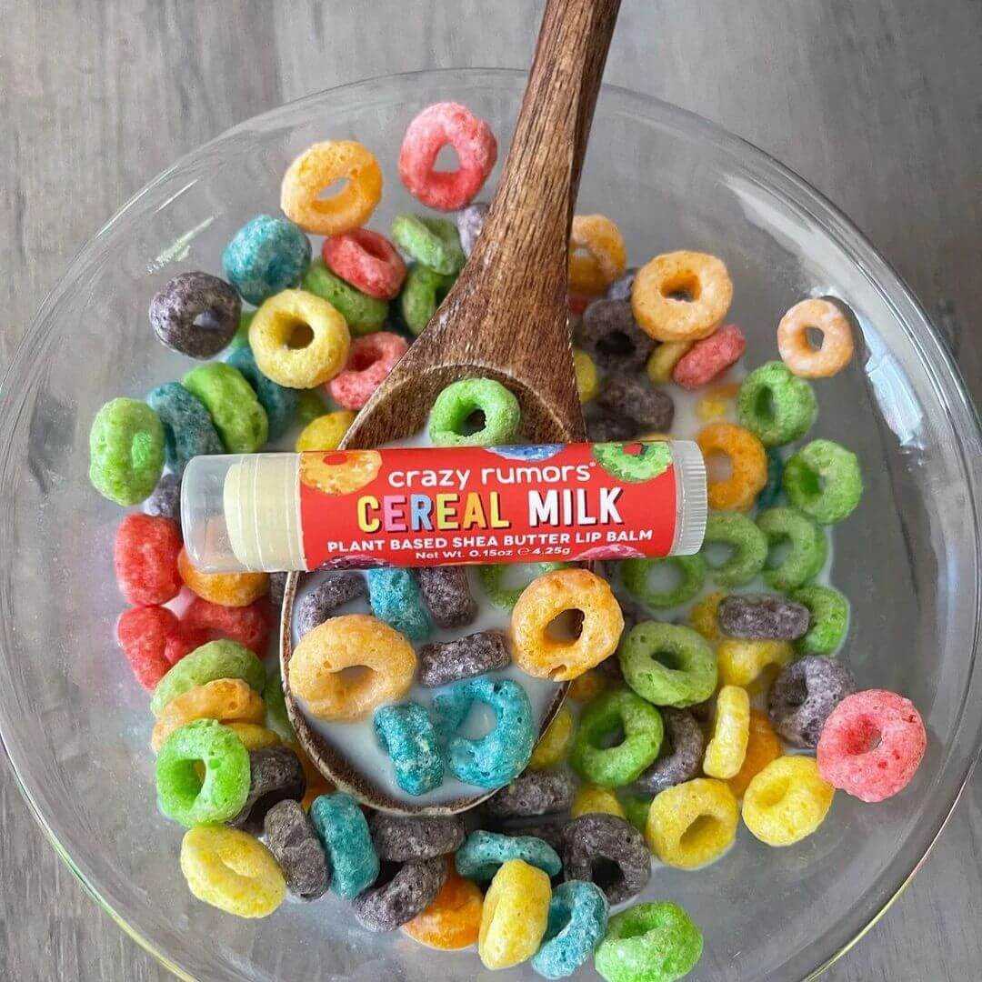 Crazy Rumors Cereal Milk lip balm in a bowl of colorful cereal.
