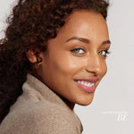 Woman wearing fitglow lip gloss in shade Be