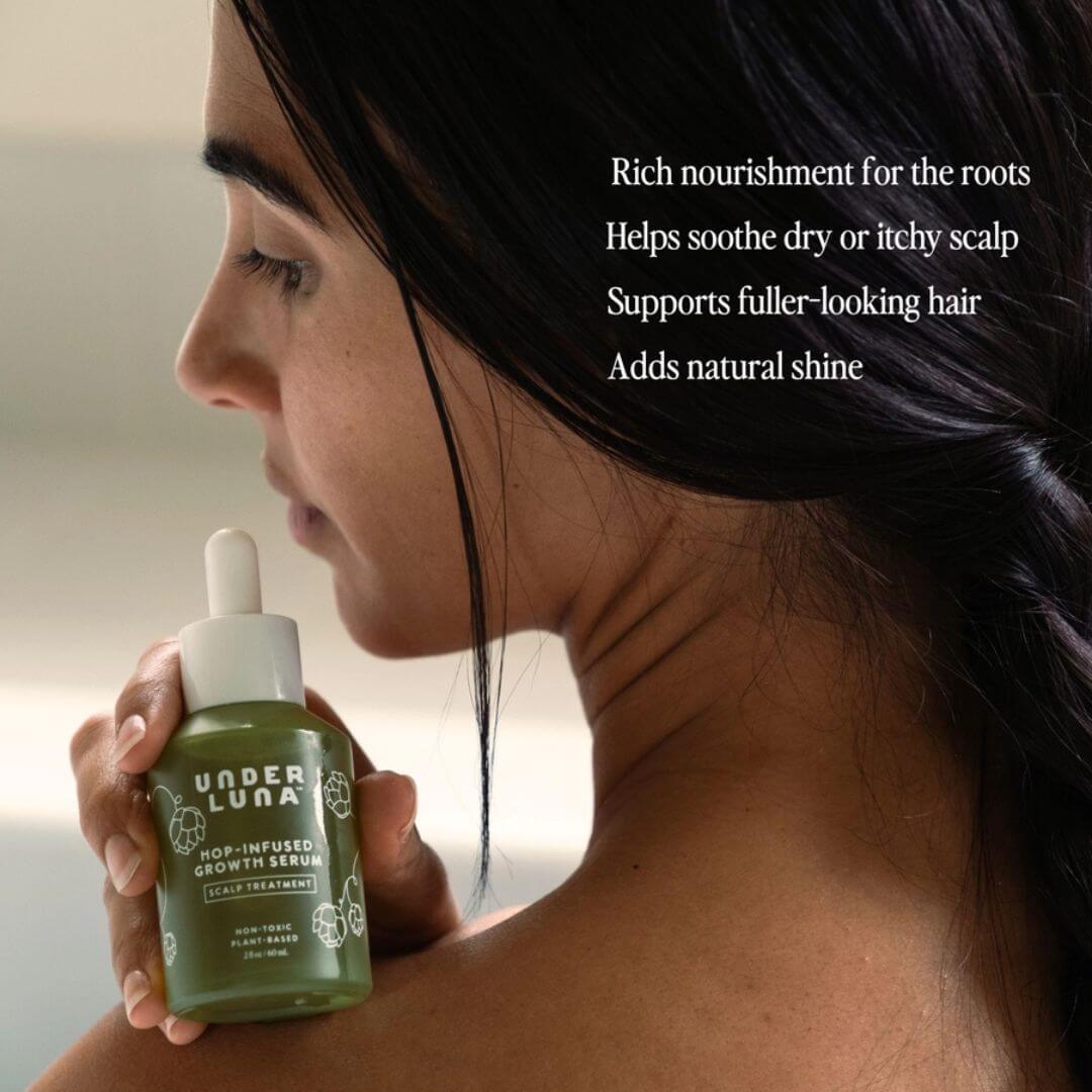 Woman holding a bottle of Under Luna hair serum with text about its benefits.