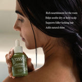 Woman holding a bottle of Under Luna hair serum with text about its benefits.