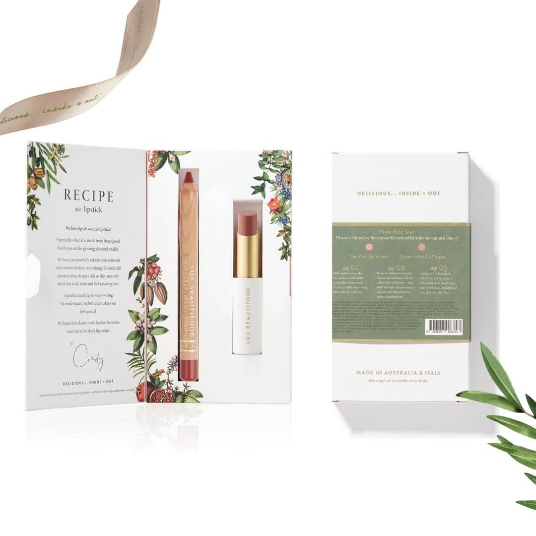 Lipstick with packaging and leaf decorations on a white background