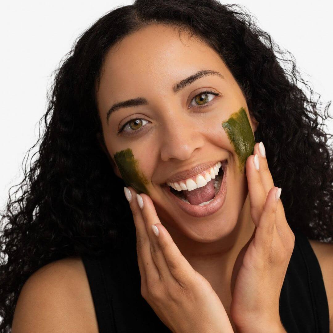 Woman applying a withSimplicity Meet Your Matcha facial mask 
