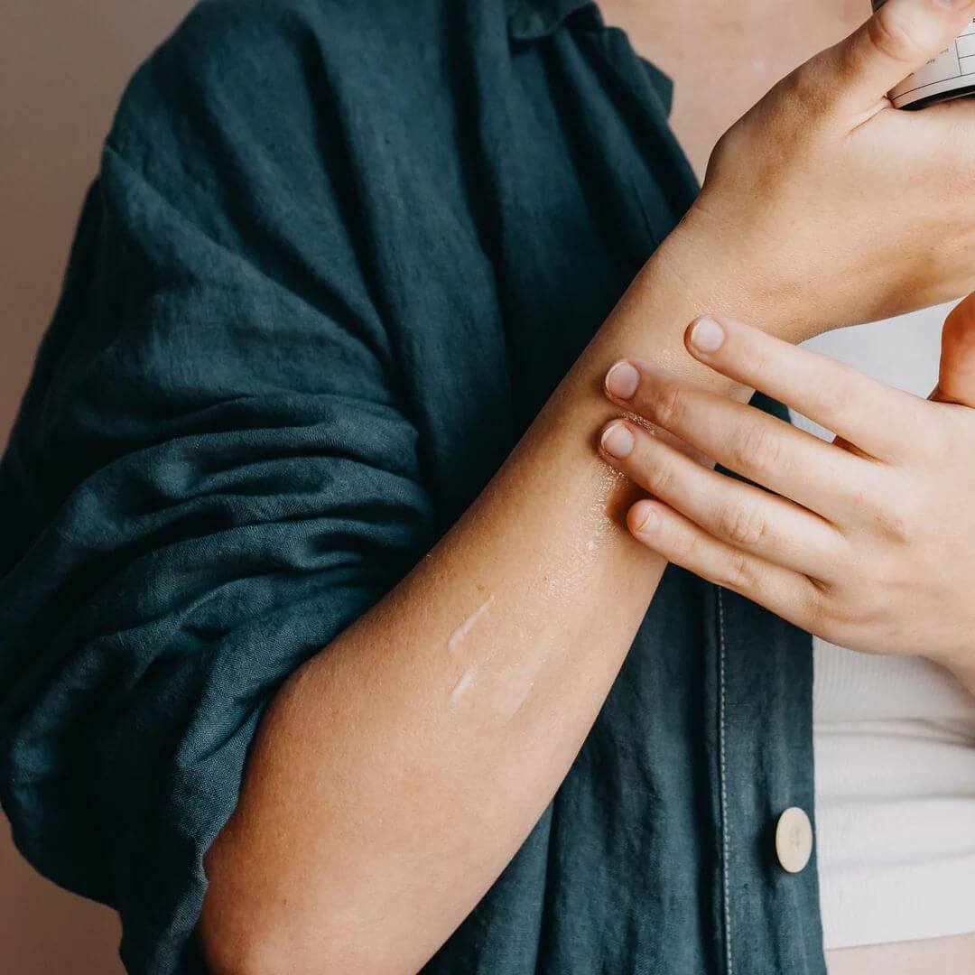 Person applying Mokosh Frankincense and orange body cream to their arm