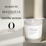 Candle with a label on a light background, featuring mentions of 'Magnolia Journal', 'Martha Stewart', and 'The Oprah Magazine'.