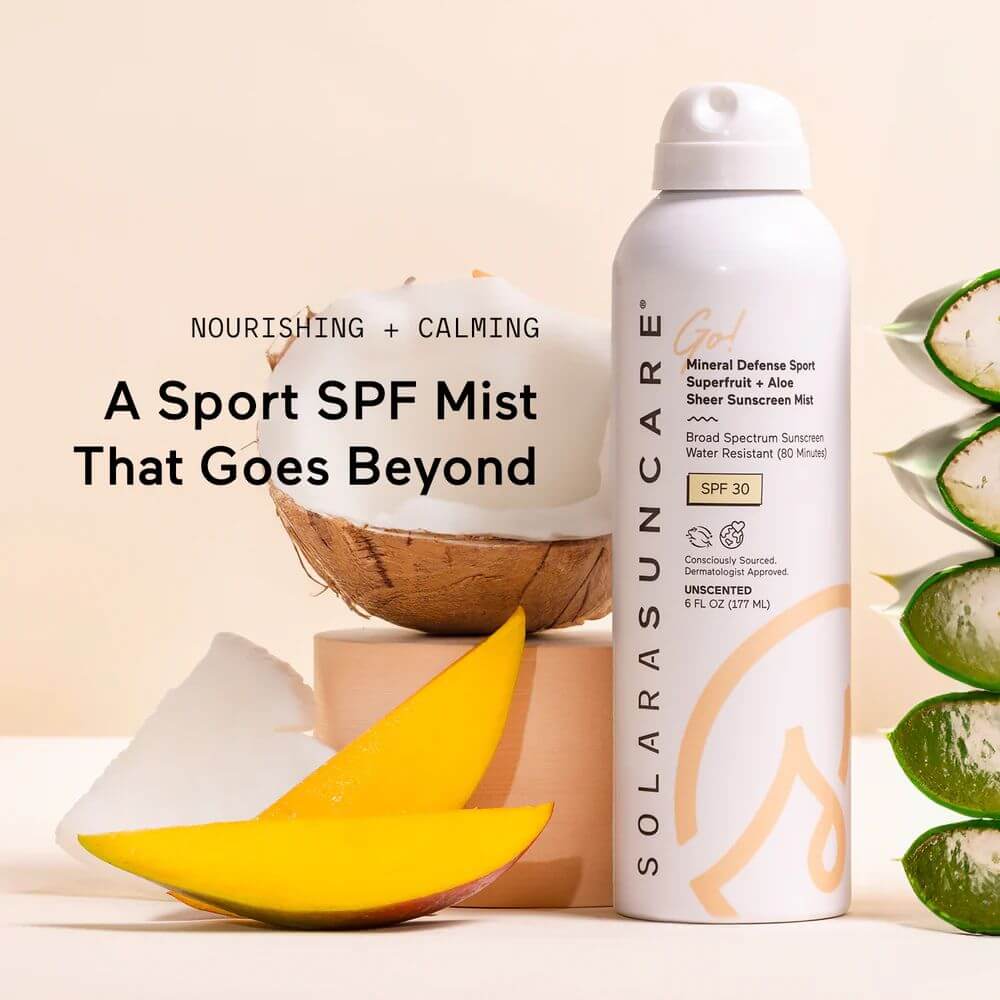 Solara Suncare SPF mist bottle with coconut, mango, and aloe vera slices on a beige background