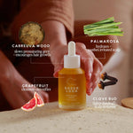 Bottle of Under Luna serum with ingredients displayed on a wooden surface